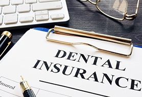 dental insurance form on a blue clipboard 