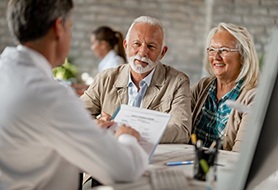 senior man and woman at a dental implant consultation 