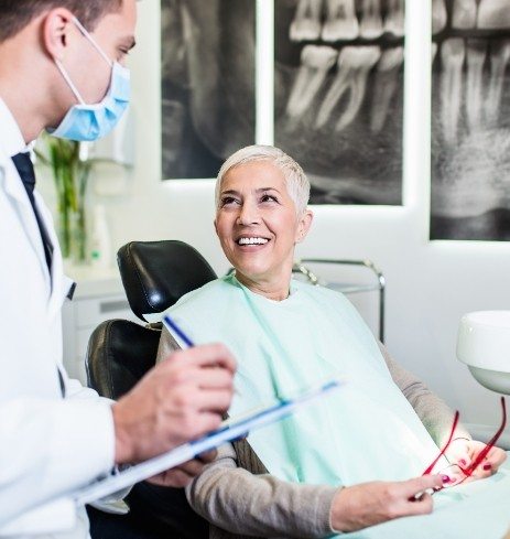 Patient talking to oral surgeon about four step dental implant process