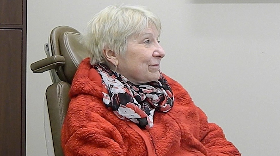 Senior woman in red coat in oral surgery office in Dumfries