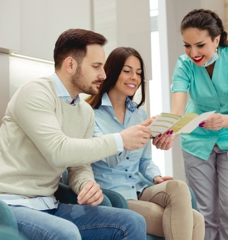 Oral surgery patients discussing insurance coverage with team member