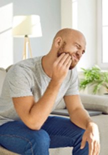 Closeup of man struggling with tooth pain at home