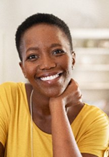 Woman in yellow shirt smiling at home