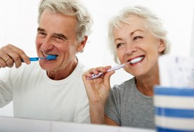 Senior couple with dental implants in Dumfries, VA brushing teeth