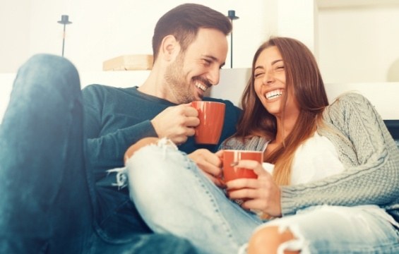 Man and woman smiling together after restorative treatment