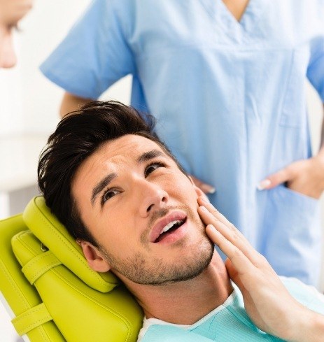 Man in need of jaw surgery holding cheek