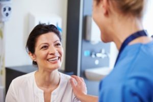 Woman smiling during her dental implant consultation.